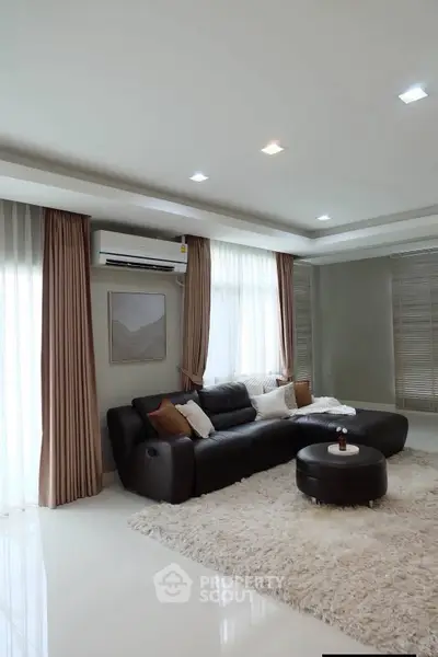 Luxurious living room with modern decor, plush rug, and elegant lighting.