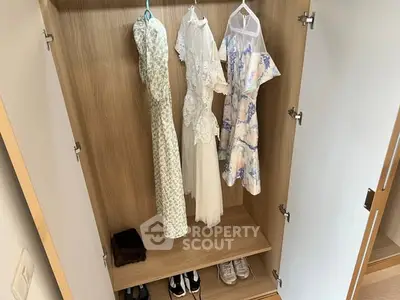 Spacious wardrobe with hanging dresses and shoes, showcasing ample storage space.