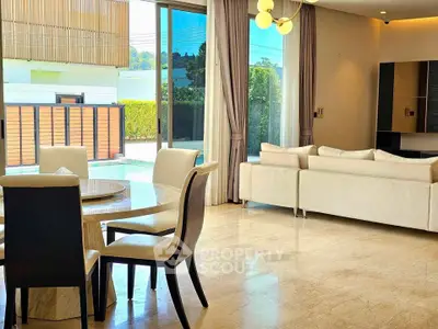 Luxurious open-plan living room with elegant furniture and pool view, perfect for modern living.
