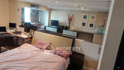 Spacious bedroom with modern decor and mirrored wall in a stylish apartment.