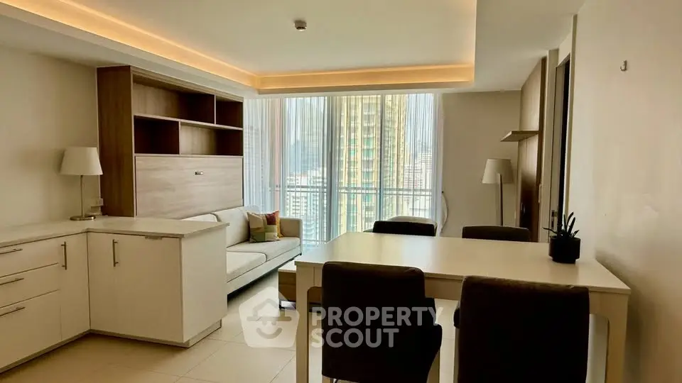 Modern living room with sleek furniture and large windows offering city views.