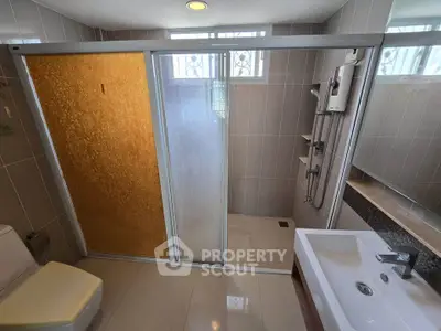 Modern bathroom with sliding glass shower doors and sleek fixtures