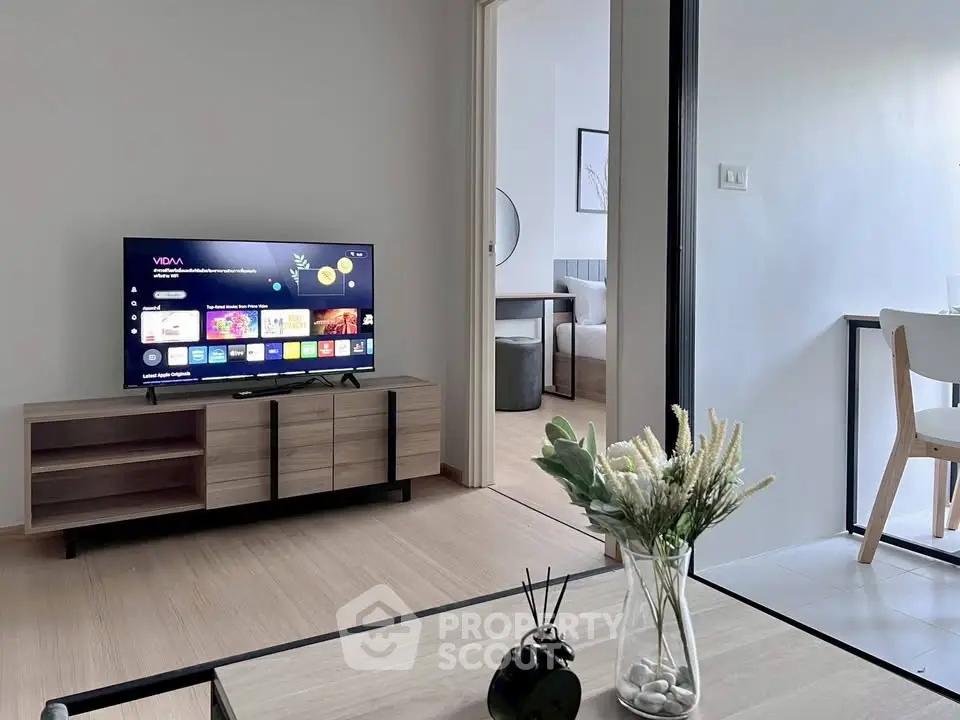 Modern living room with sleek TV setup and stylish decor in a contemporary apartment.