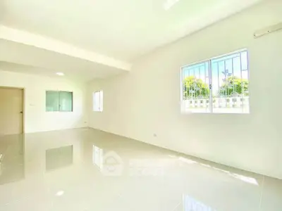 Spacious and bright living room with glossy tile flooring and large windows.