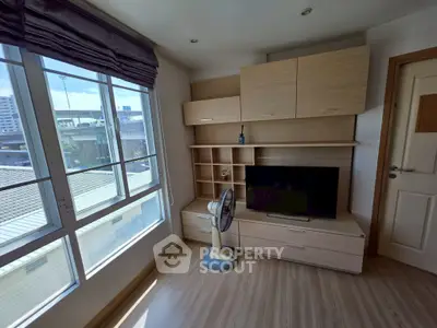 Modern living room with large windows and built-in wooden entertainment unit.
