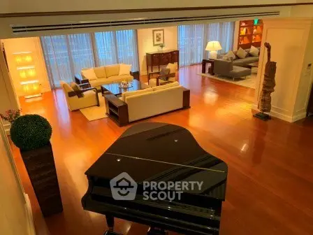 Luxurious living room with grand piano and elegant seating area, featuring floor-to-ceiling windows and warm lighting.