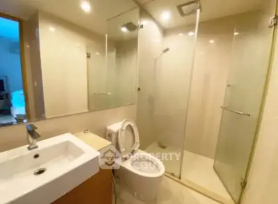 Modern bathroom with glass shower and sleek fixtures in a contemporary apartment.
