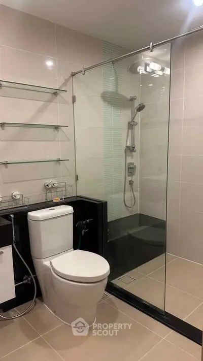 Modern bathroom with glass shower enclosure and sleek fixtures.