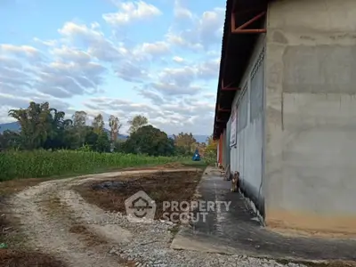 Rural warehouse exterior with scenic countryside view and gravel path