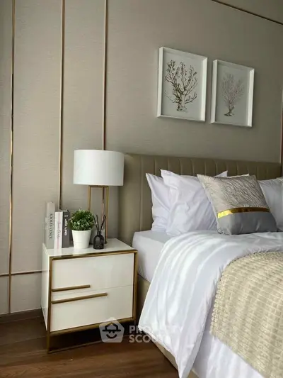 Luxurious bedroom with elegant decor, featuring a plush bed, stylish nightstand, and tasteful wall art.