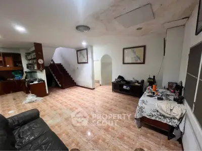 Spacious living room with staircase and tiled flooring in a cozy home.