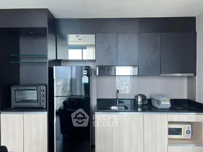 Modern kitchen with sleek black cabinets, appliances, and a city view window.