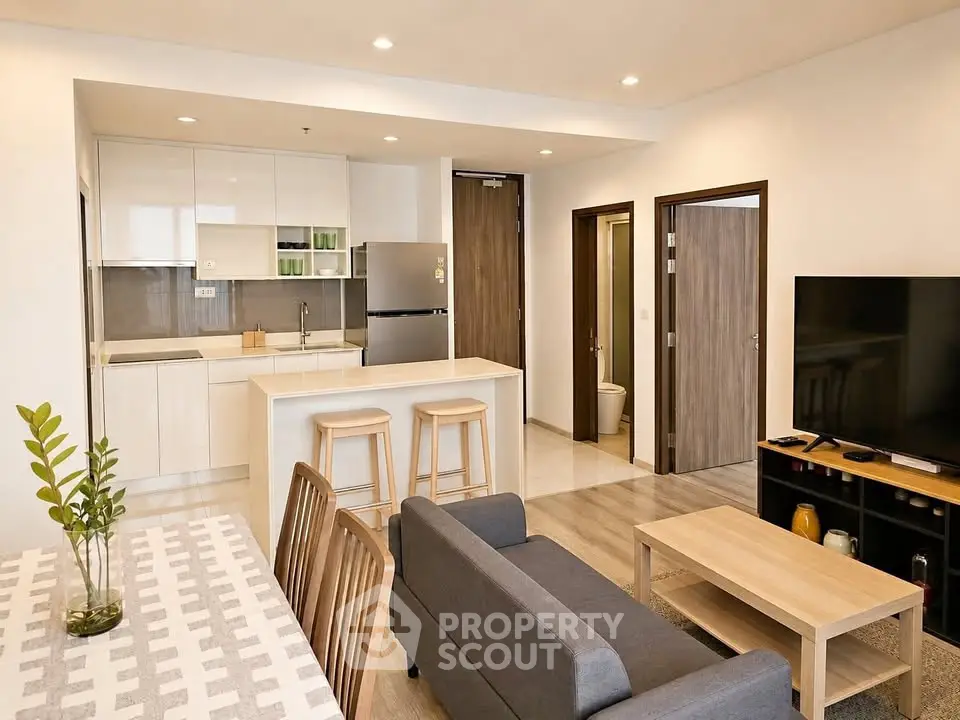 Modern open-plan living room and kitchen with stylish furniture and appliances