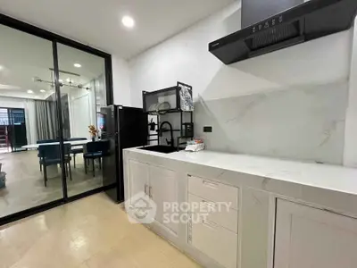 Modern kitchen with sleek design and open layout, featuring marble countertops and contemporary appliances.