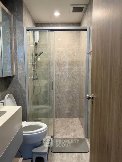Modern bathroom with glass shower and sleek fixtures in a contemporary apartment.