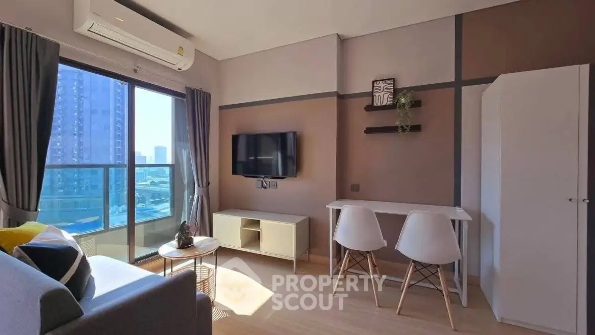 Modern living room with balcony view, stylish furniture, and natural light in urban apartment.