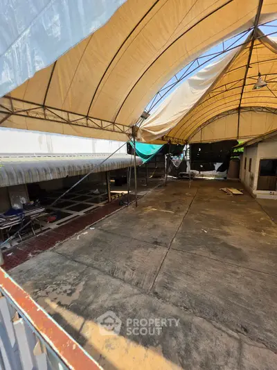 Spacious rooftop area with canopy, ideal for outdoor events or relaxation.