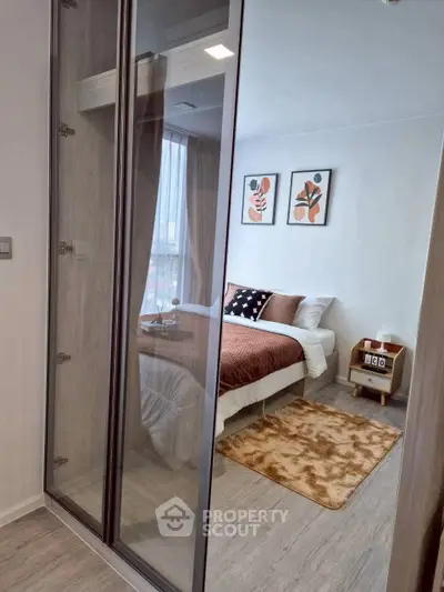 Modern bedroom with stylish decor and large glass wardrobe doors