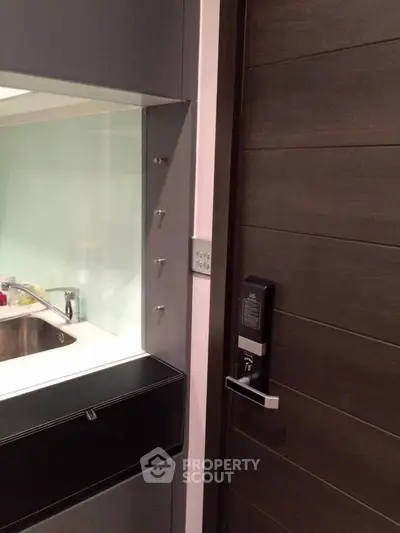 Modern kitchen with sleek cabinetry and electronic door lock for enhanced security.