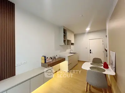 Modern kitchen with sleek cabinetry and cozy dining area in stylish apartment.