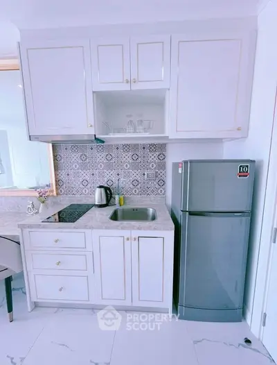 Modern kitchen with sleek cabinetry and stainless steel fridge in a stylish apartment.