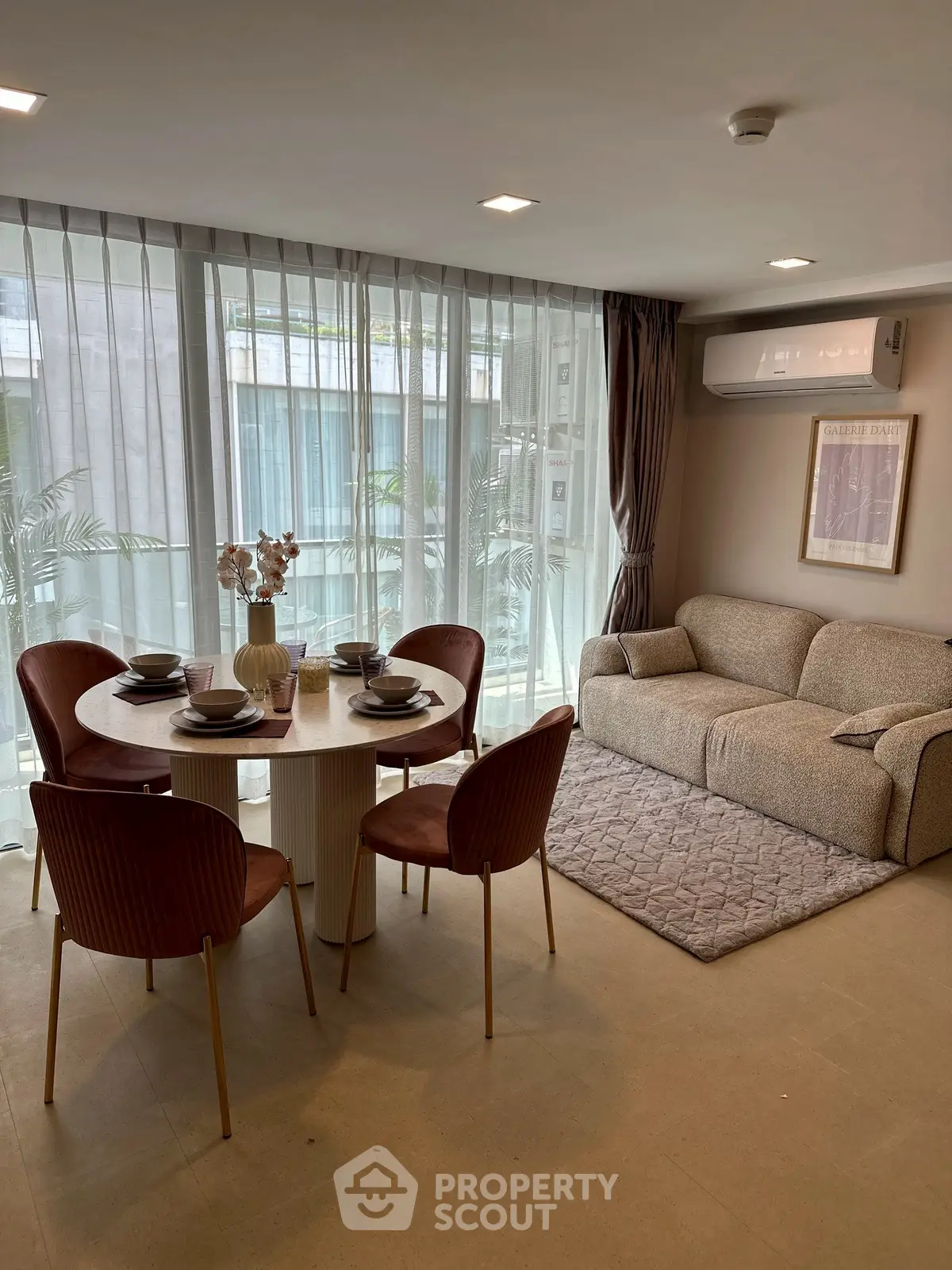 Modern living room with cozy sofa and dining area, featuring elegant decor and natural light.