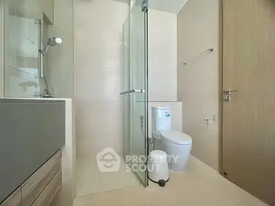 Modern bathroom with glass shower and sleek fixtures in a contemporary apartment.