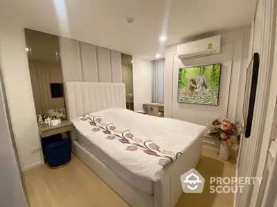 Cozy bedroom with modern decor, featuring a plush bed, air conditioning, and stylish wall art.