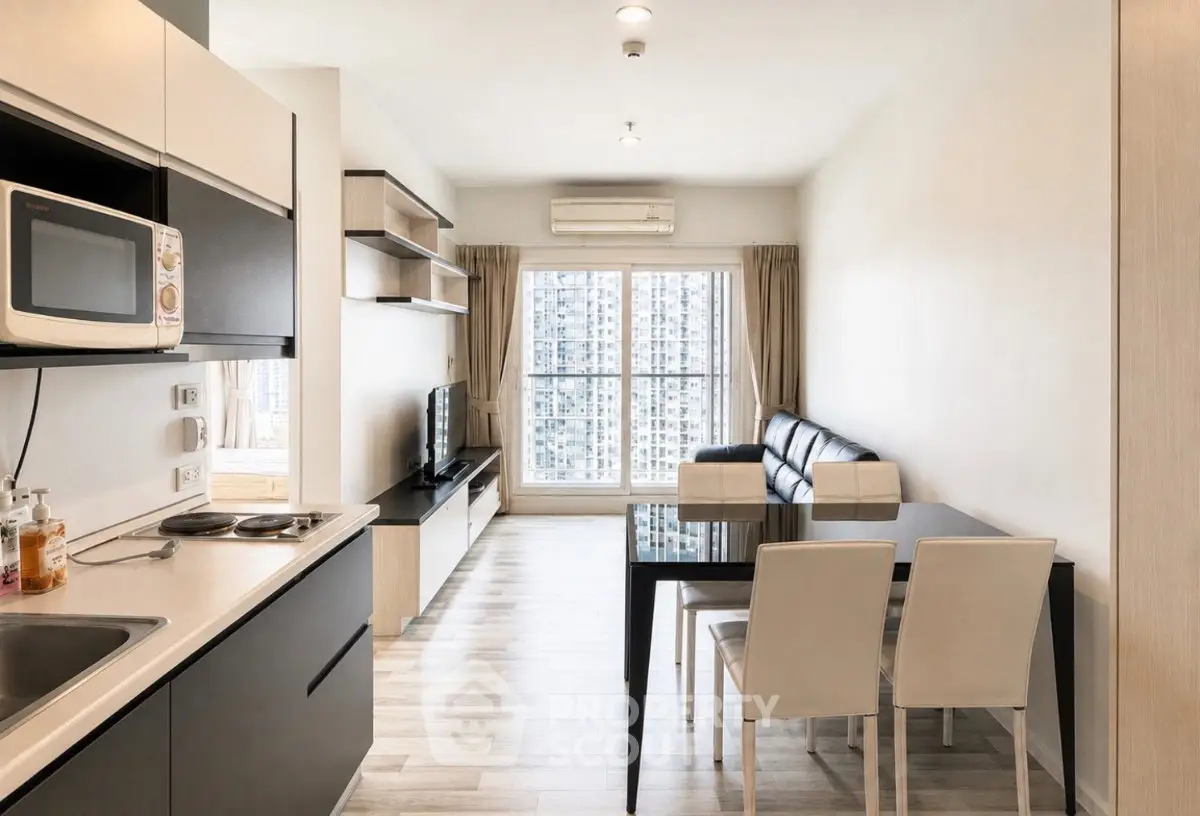 Modern open-layout living room with kitchen, featuring sleek furniture and large windows with city view.