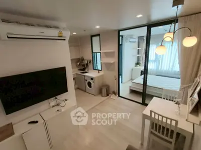 Modern studio apartment with open layout, featuring a cozy living area, compact kitchen, and bright bedroom.