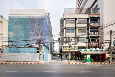 Street view of urban buildings with construction site and commercial area.