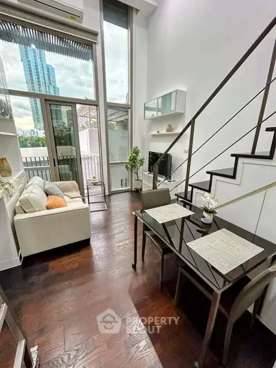 Modern duplex living room with high ceilings and city view balcony