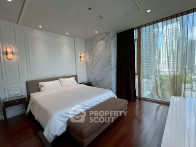 Luxurious bedroom with elegant decor and city view, featuring a king-size bed and floor-to-ceiling windows.