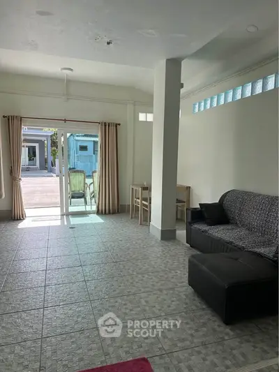 Spacious living room with tiled floor and sliding glass doors leading to outdoor area.