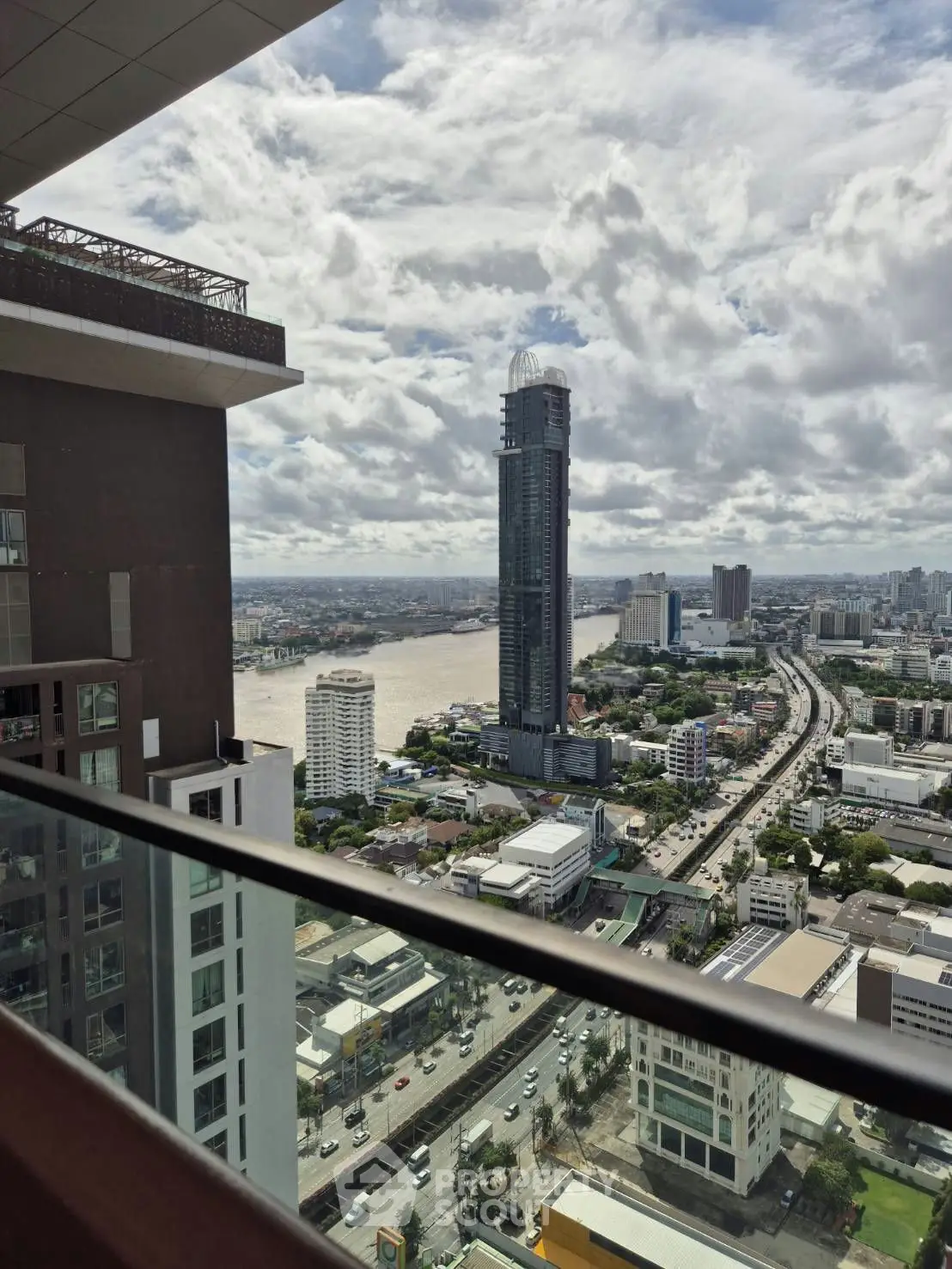 Stunning cityscape view from high-rise balcony overlooking river and skyline.