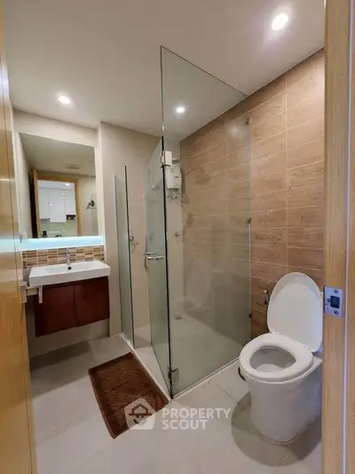 Modern bathroom with glass shower and sleek fixtures in a contemporary home.