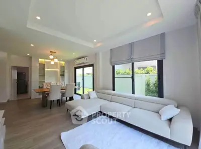 Spacious modern living room with elegant dining area and large windows for natural light.