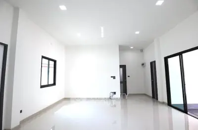 Spacious modern living room with large windows and sleek tile flooring.