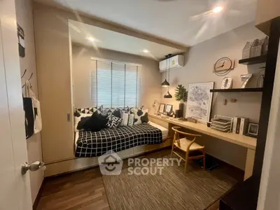 Stylish modern bedroom with cozy bed, sleek desk, and chic decor in a compact space.