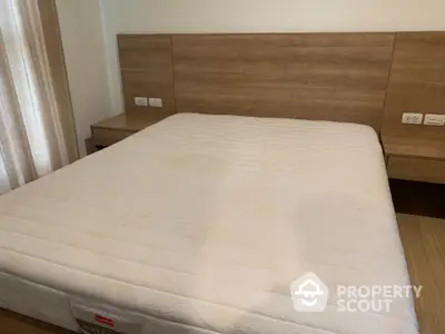 Spacious bedroom with modern wooden headboard and comfortable mattress