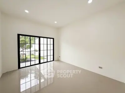 Spacious empty room with large windows and glossy tiled floor, perfect for customization.