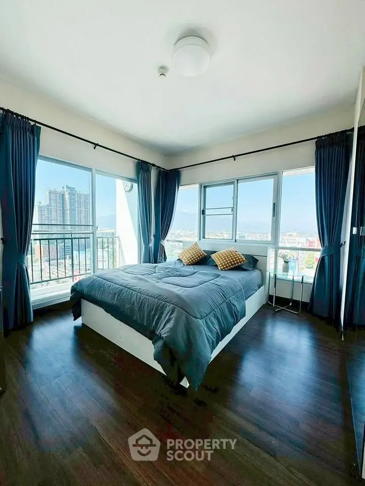 Spacious bedroom with panoramic city views and modern decor