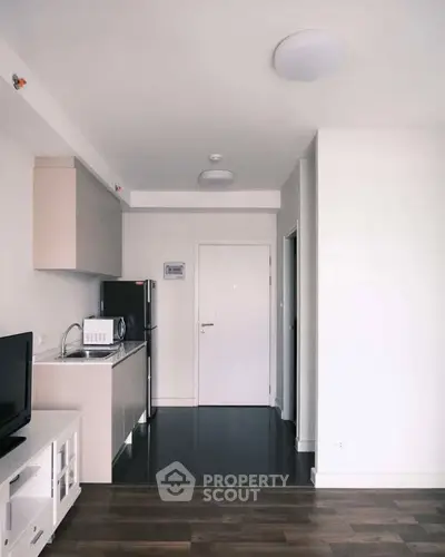 Modern compact kitchen with sleek appliances and minimalist design in a cozy apartment.