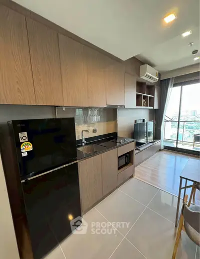 Modern kitchen with sleek cabinetry and appliances in open-plan living area with city view.