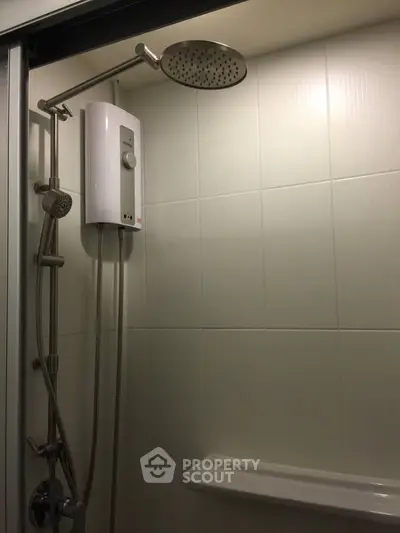 Modern bathroom shower with sleek fixtures and water heater in a stylish real estate property.