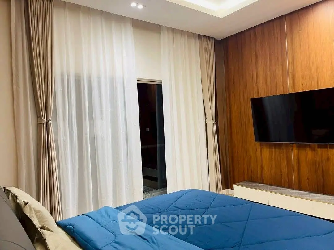 Modern bedroom with sleek wooden paneling and wall-mounted TV