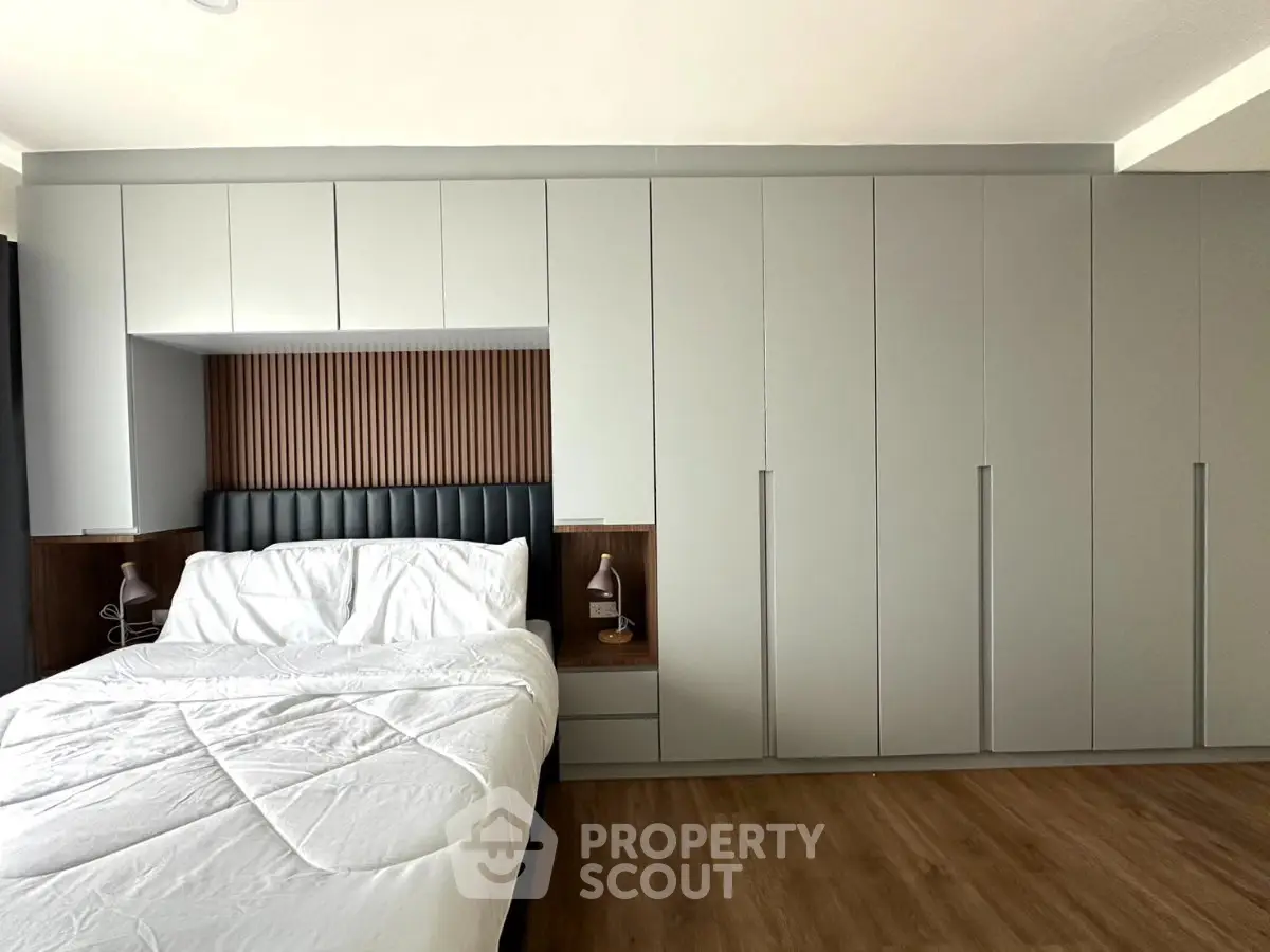 Modern bedroom with sleek built-in wardrobes and cozy bed setup