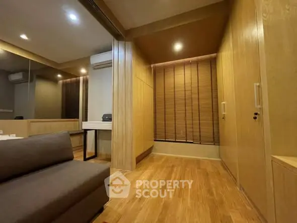 Spacious modern living room with wooden flooring and stylish blinds