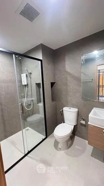 Modern bathroom with glass shower enclosure and sleek fixtures