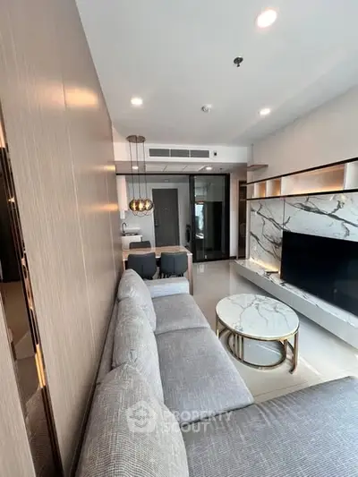 Modern living room with elegant marble accents and cozy gray sofa